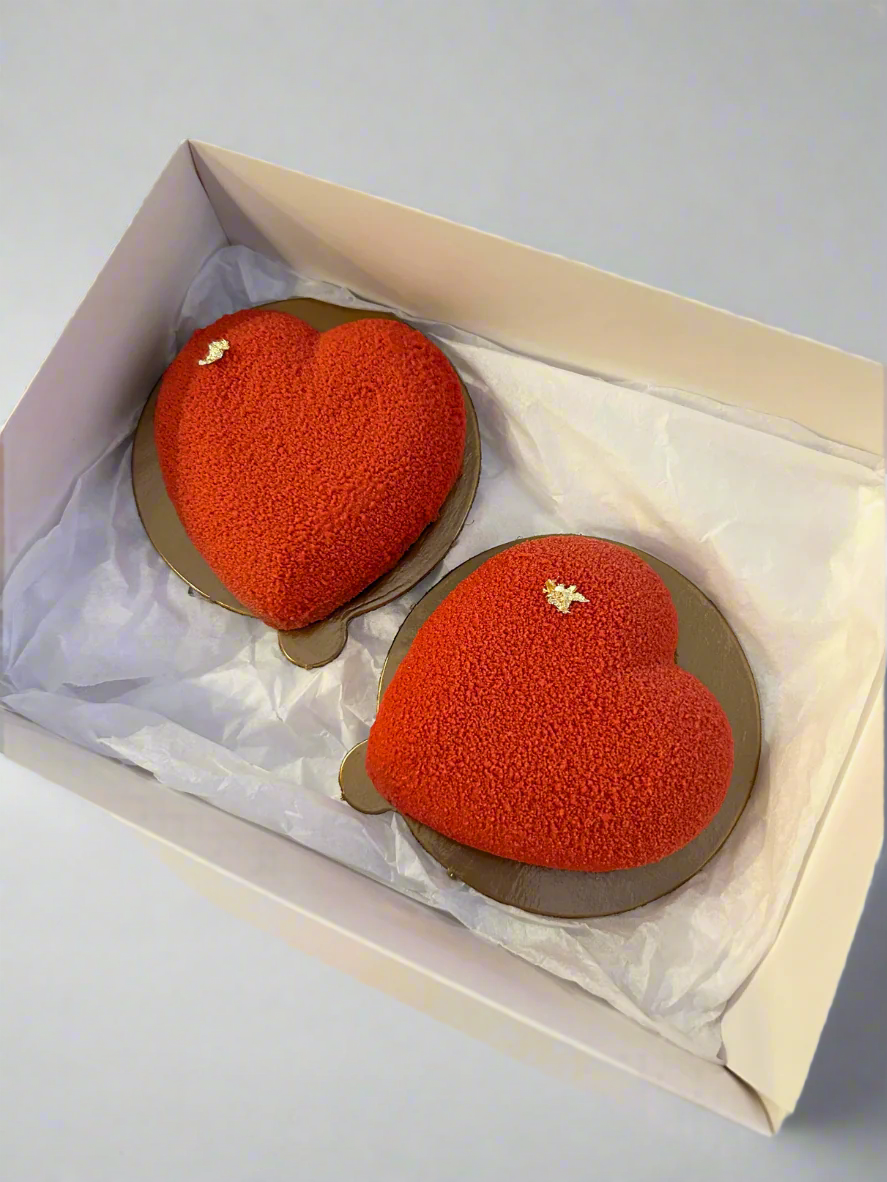 two mini heart shaped mousse cakes in white box