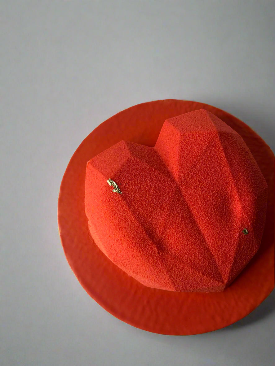 Red heart shaped mousse cake with touch of gold
