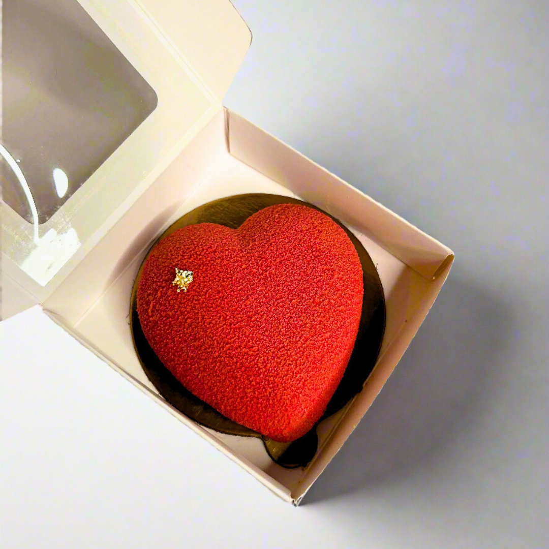 mini heart shaped mousse dessert in white box on the grey background 