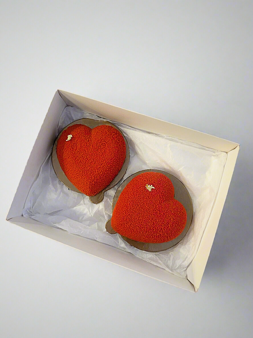 two mini heart shaped mousse dessert in white box 