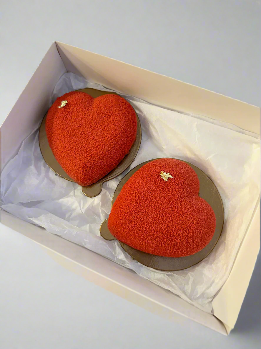 two mini heart shaped mousse cakes in white box 